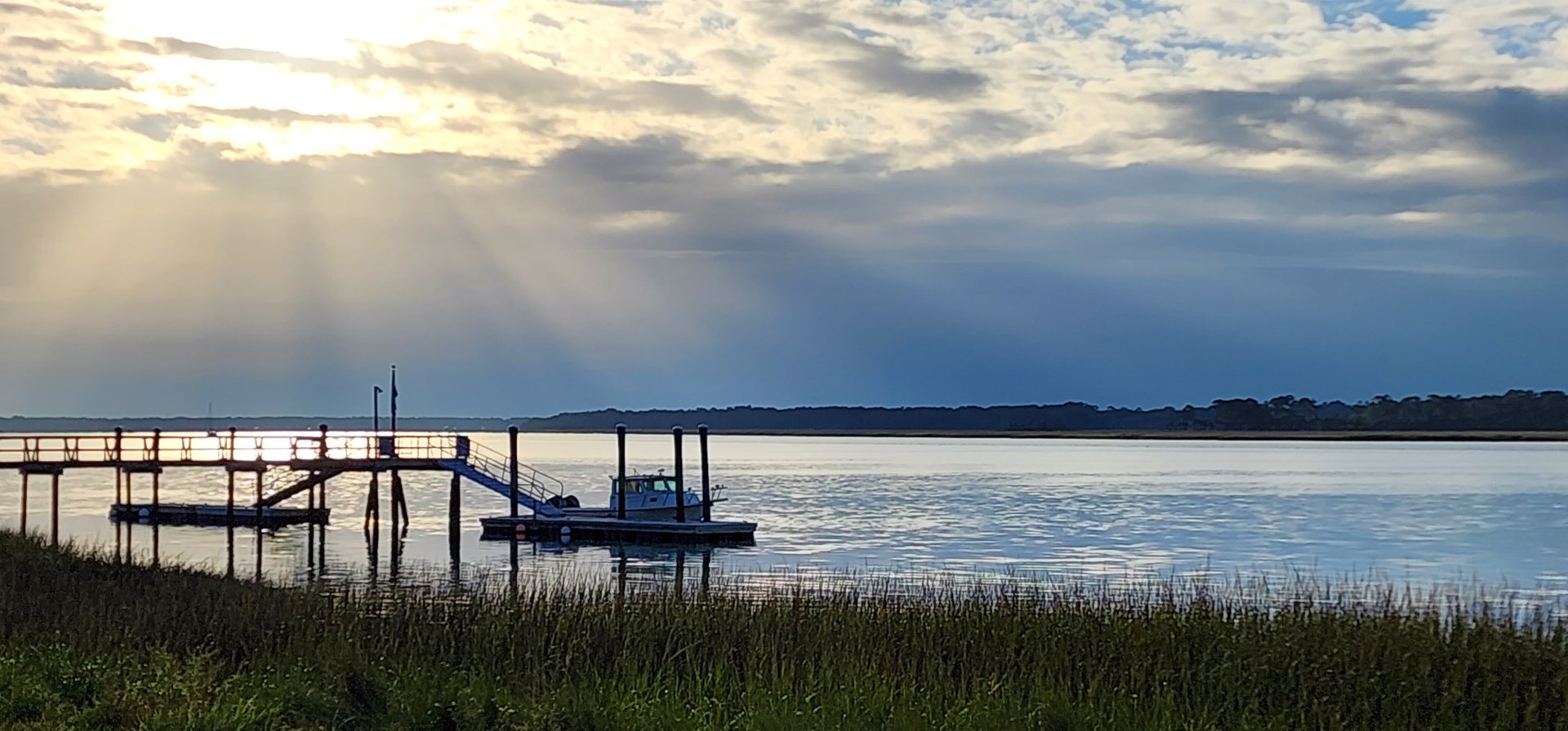 The May River, a dock, and marsh grass beneath an evening sky